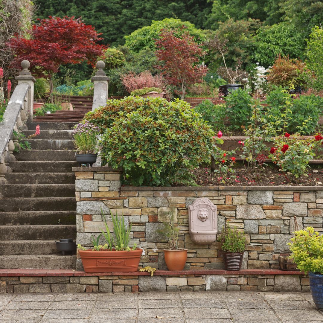 Terraced garden with stone steps, potted plants, and colorful landscaping